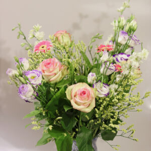 Volledig Pastel Liefde bloemenboeket met roze rozen en paarse bloemen in glazen vaas