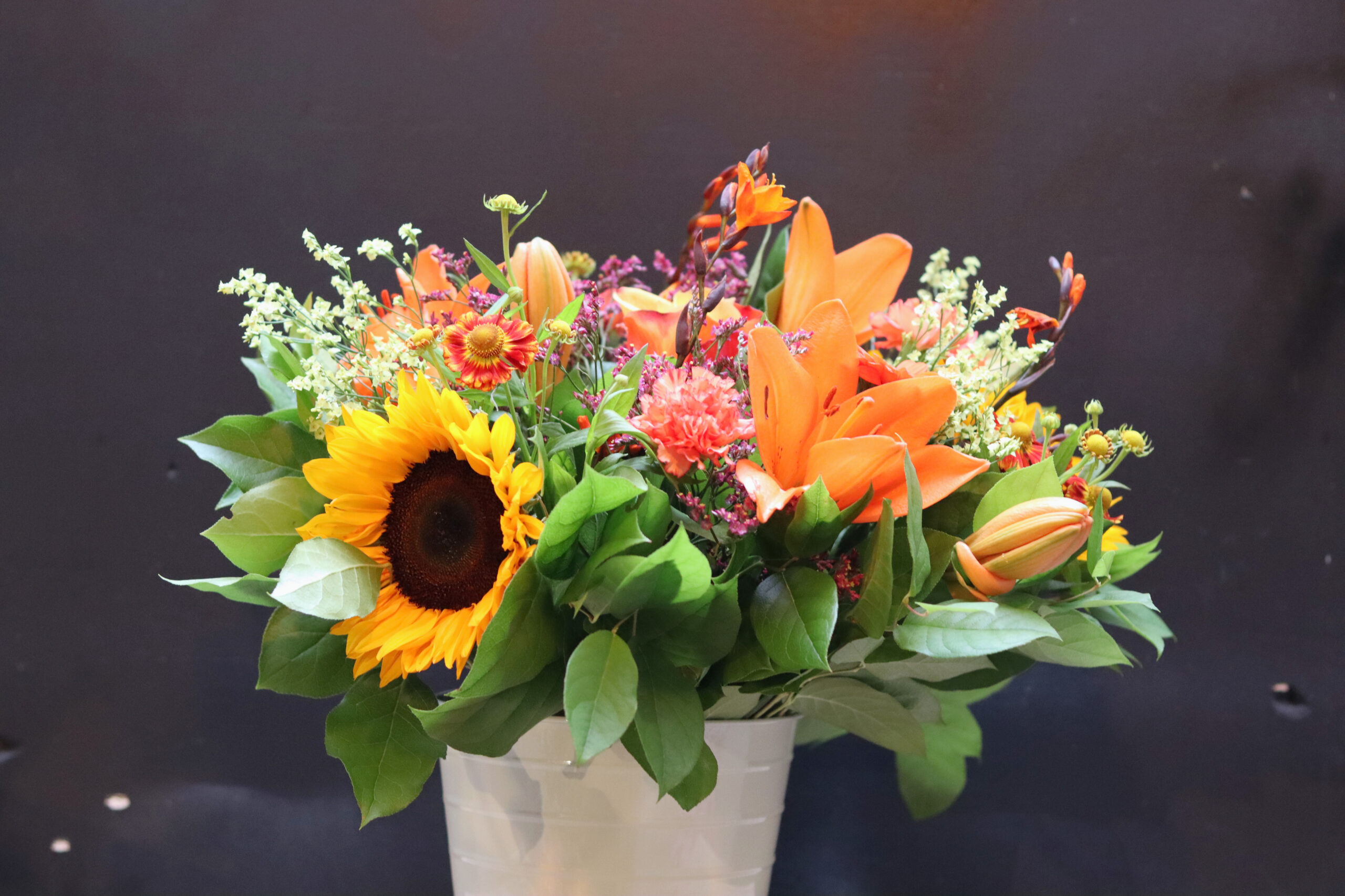 Breed Zonnegloed bloemenboeket met zonnebloemen, oranje lelies en groen blad